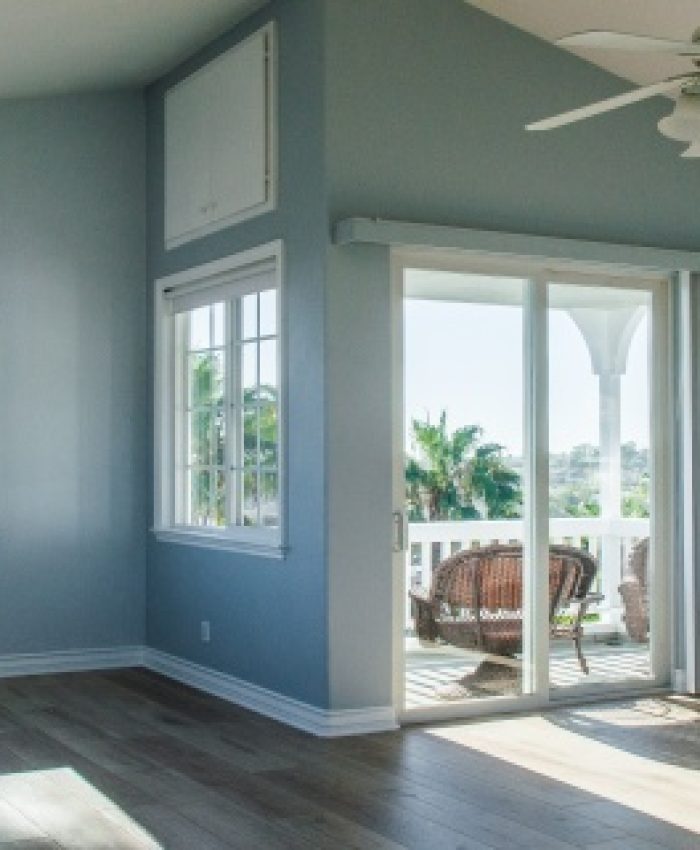 A trendy modern interior of a living room with blue walls and white windows