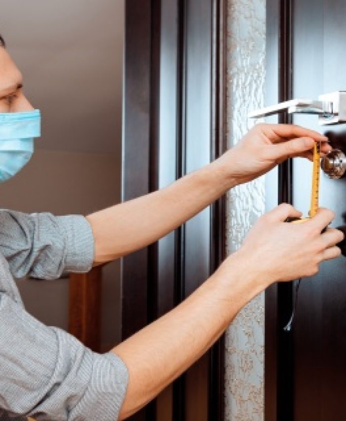 man repairing the doorknob. closeup of worker's hands installing new door locker